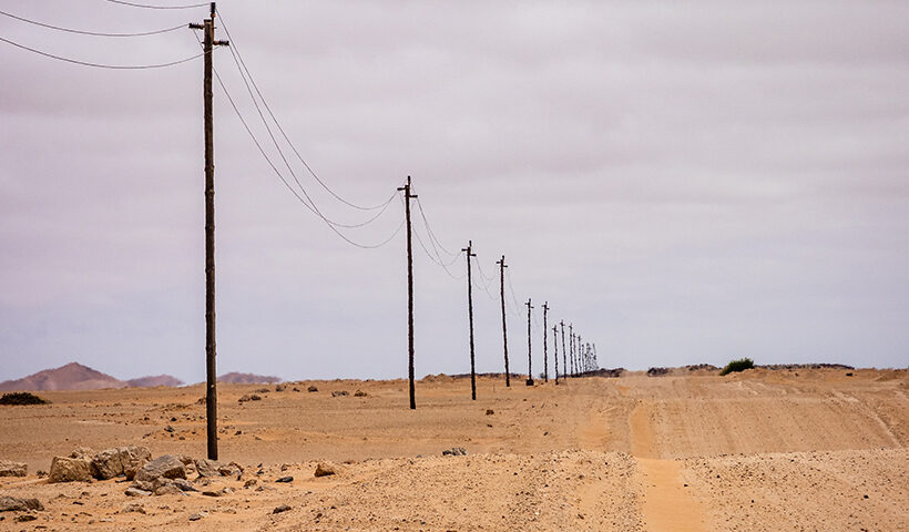 Línea de postes que se pierden en el horizonte de un desierto